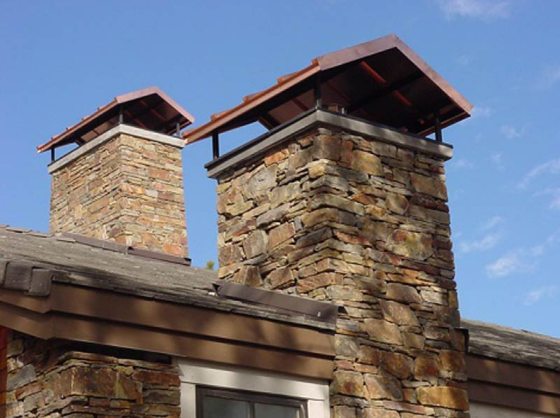 Brand new chimney caps on a stone chimney